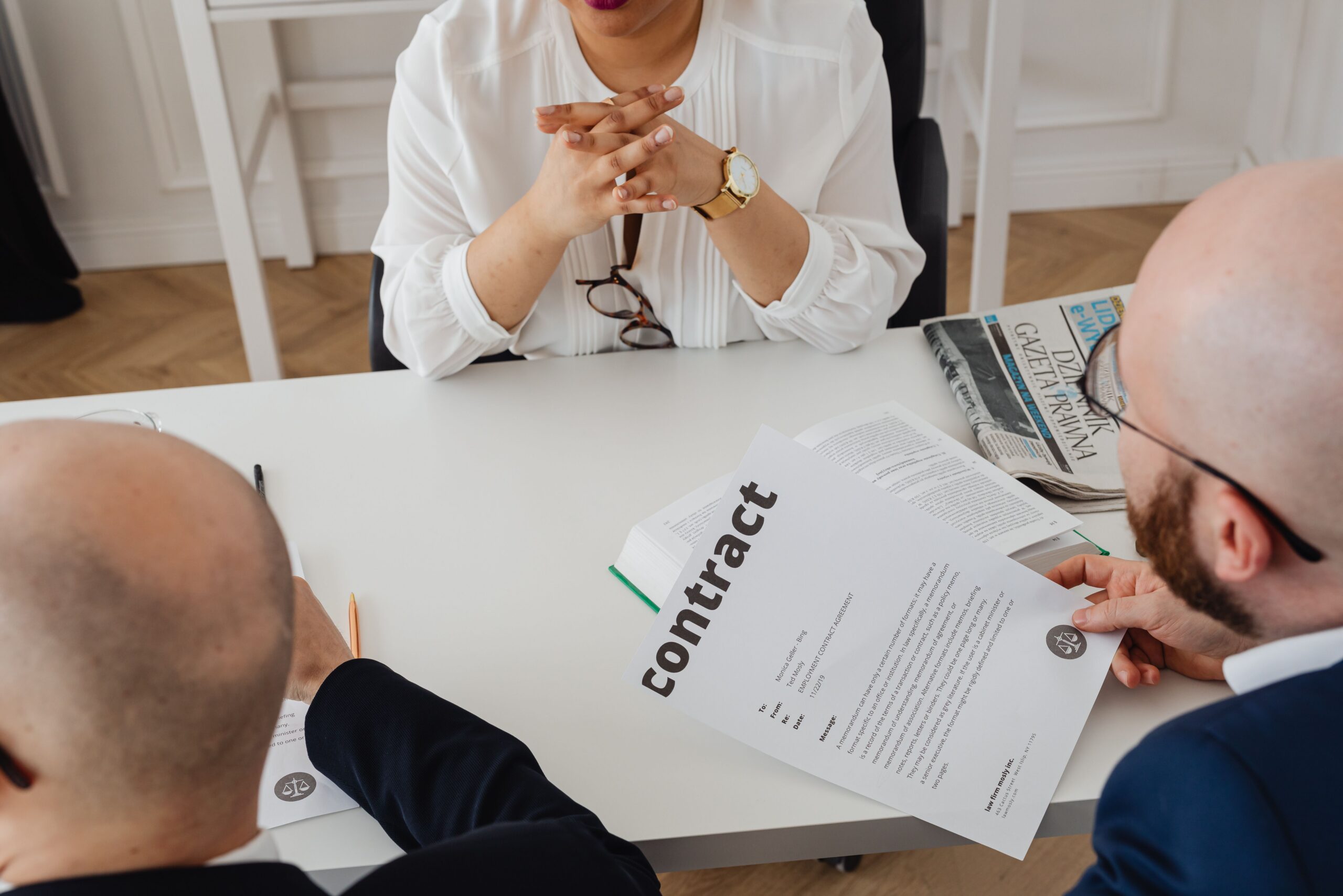 Business professionals discussing a contract in a modern office setting.